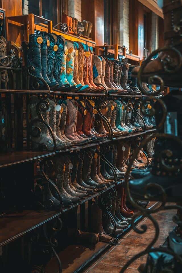 Cowboy boots lined up on a 4 tier iron rack
