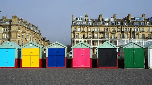 Hove Beach Huts - colurful bathing boxes in front of Victorian era buildings behind them