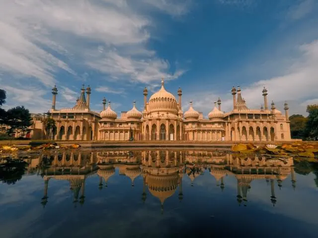 Asian inspired Royal Pavillion building behind a body of water in which it is reflected