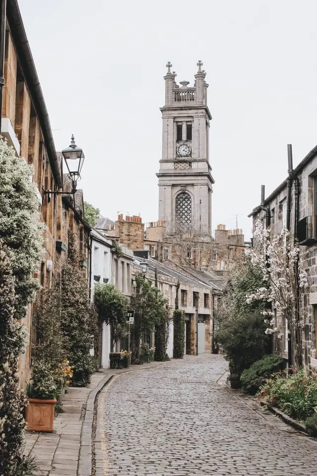 Curved circus lane in Edinburgh with the chirch spire standing tall above the mews houses at the back of the shot