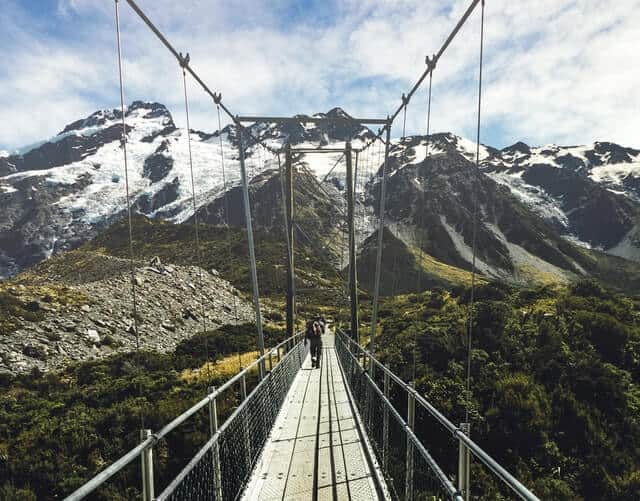 Hooker Valley Swingbridge with snow covered peaks in the backgrounde