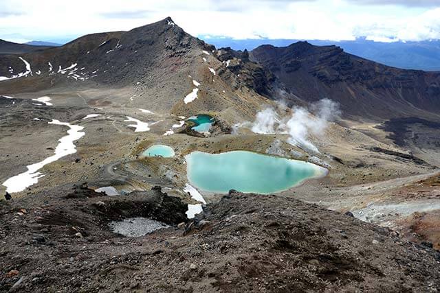 Tongariro Alpine Crossing Trail punctuated by light blue mountain pools