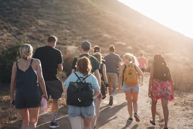 Group of people on a hike carrying small backpacks and bottles of water