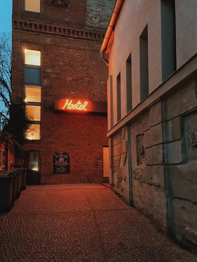 Neon hostel sign on a brick wall