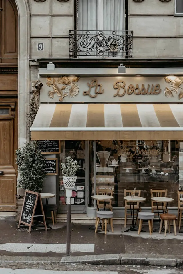 Cafe in Paris with outisde seating under a striped conopy