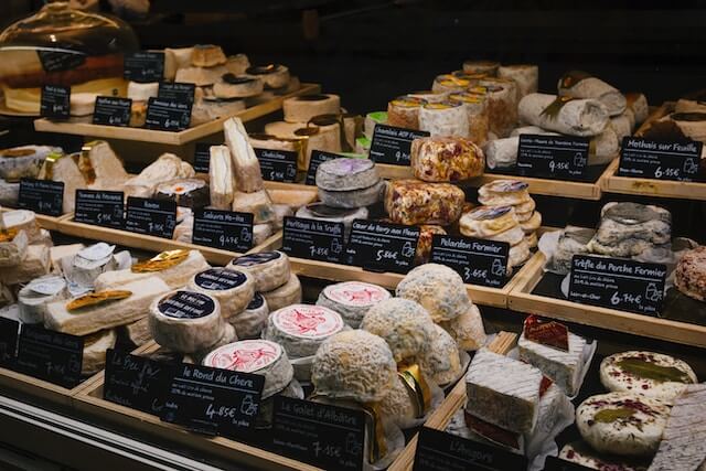 Stall with multiple different French cheeses displayed