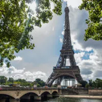Top 10 Reasons to Visit Paris cover photo of the Eiffel tower, taken from Trocadero Gardens with the Seine in the foreground