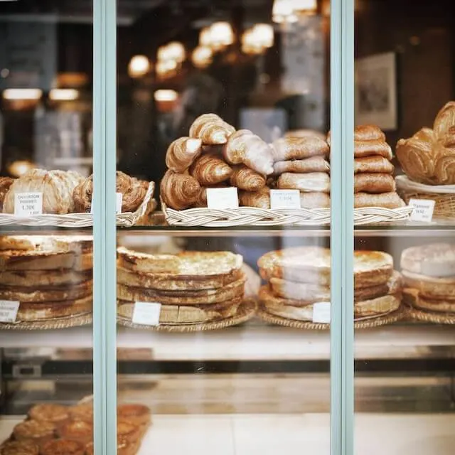 Window of a bakery in Paris with pastries and croissants on display