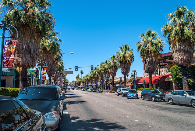 Downtown Palm Springs - palm tree lined road with shops, boutiques and restaurants on both sides of the sidewalk