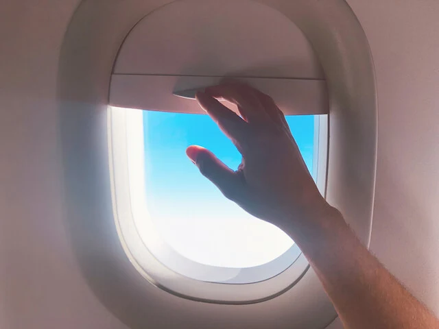 Hand closing a plane window