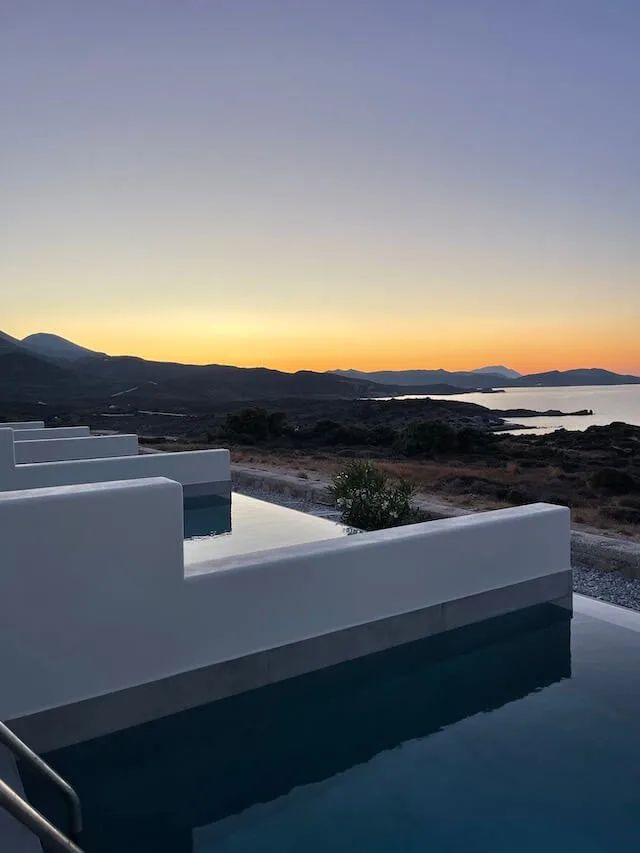 Sunset in Milos with a small private pool in the foreground, high on a hill looking out to the ocean