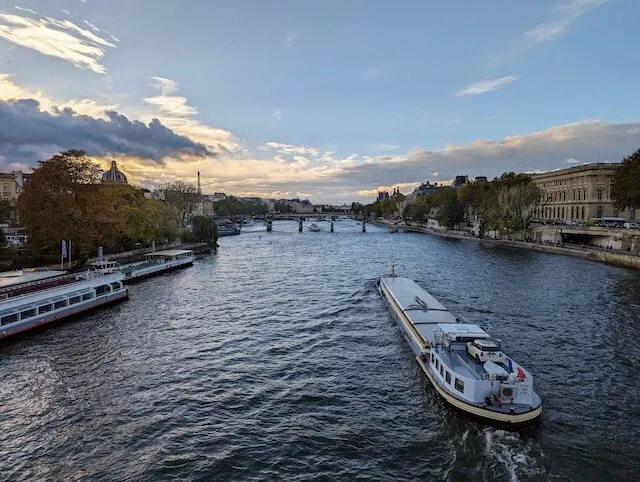 Seine River at Sunset, a boat traveling away from the bridge where the photographer is standing