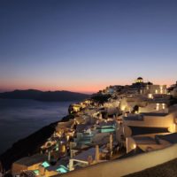 Athens Mykonos Santorini Itinerary cover photo of a sunset at Oia on Santorini