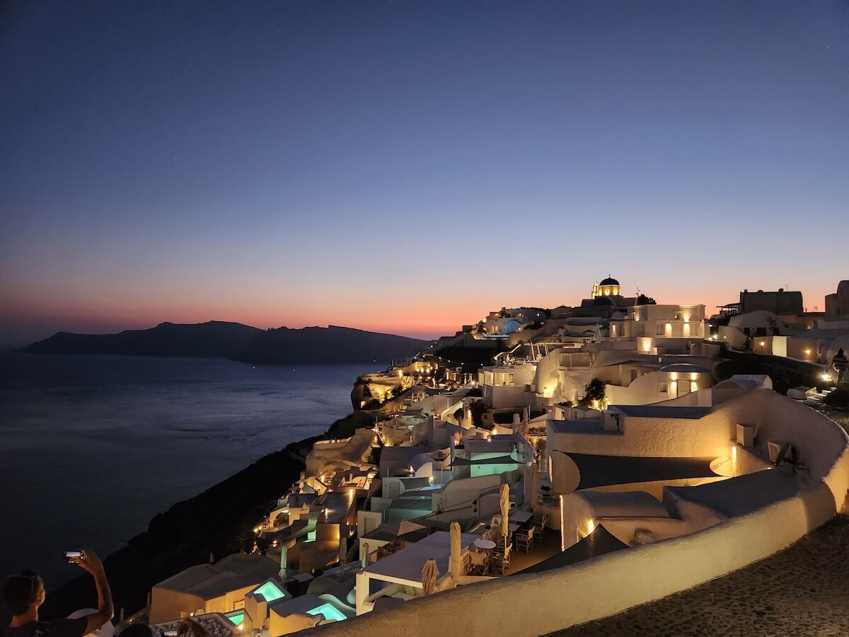 Athens Mykonos Santorini Itinerary cover photo of a sunset at Oia on Santorini
